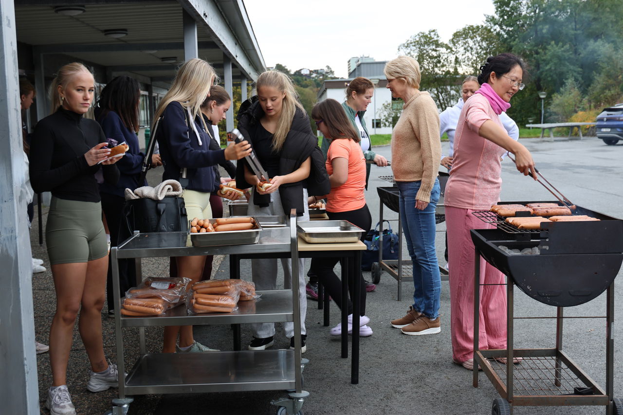 Foto av lærere og elever som griller pølser