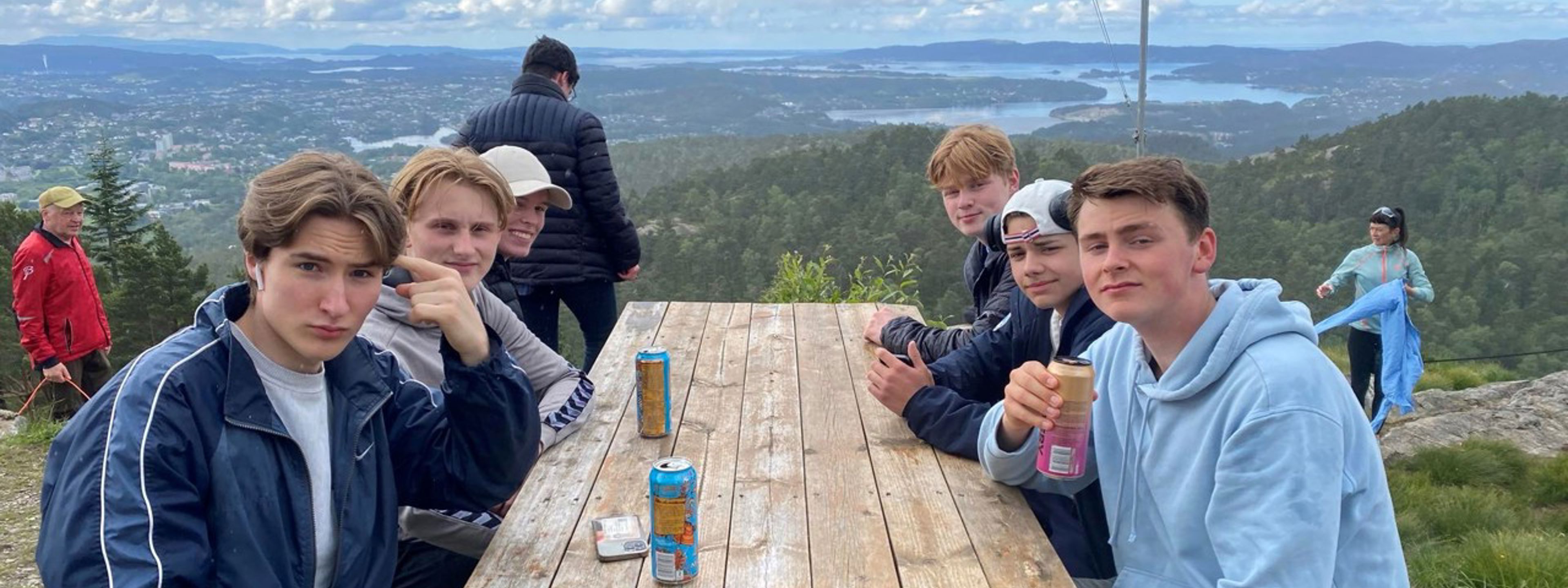 Foto av elever rundt bord med utsikt i bakgrunnen