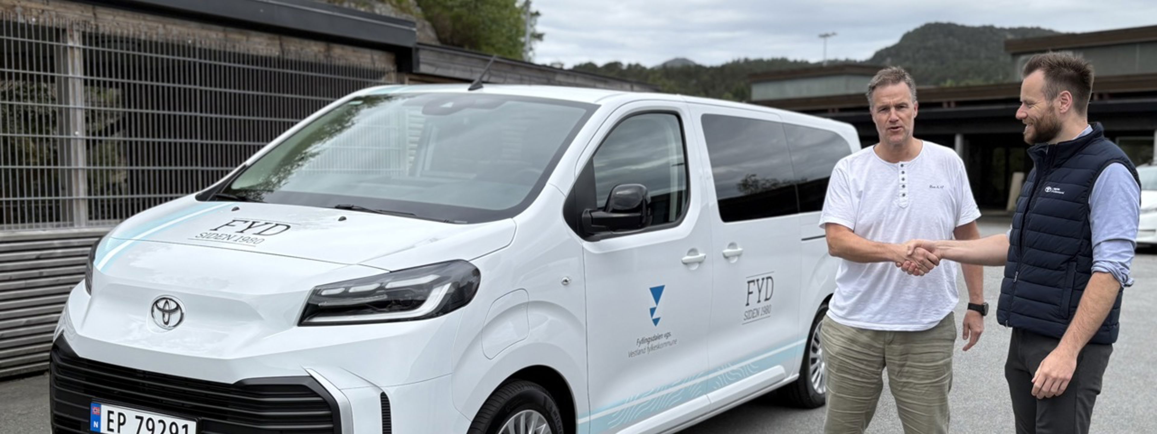 Foto av rektor som tar i mot skolebilen