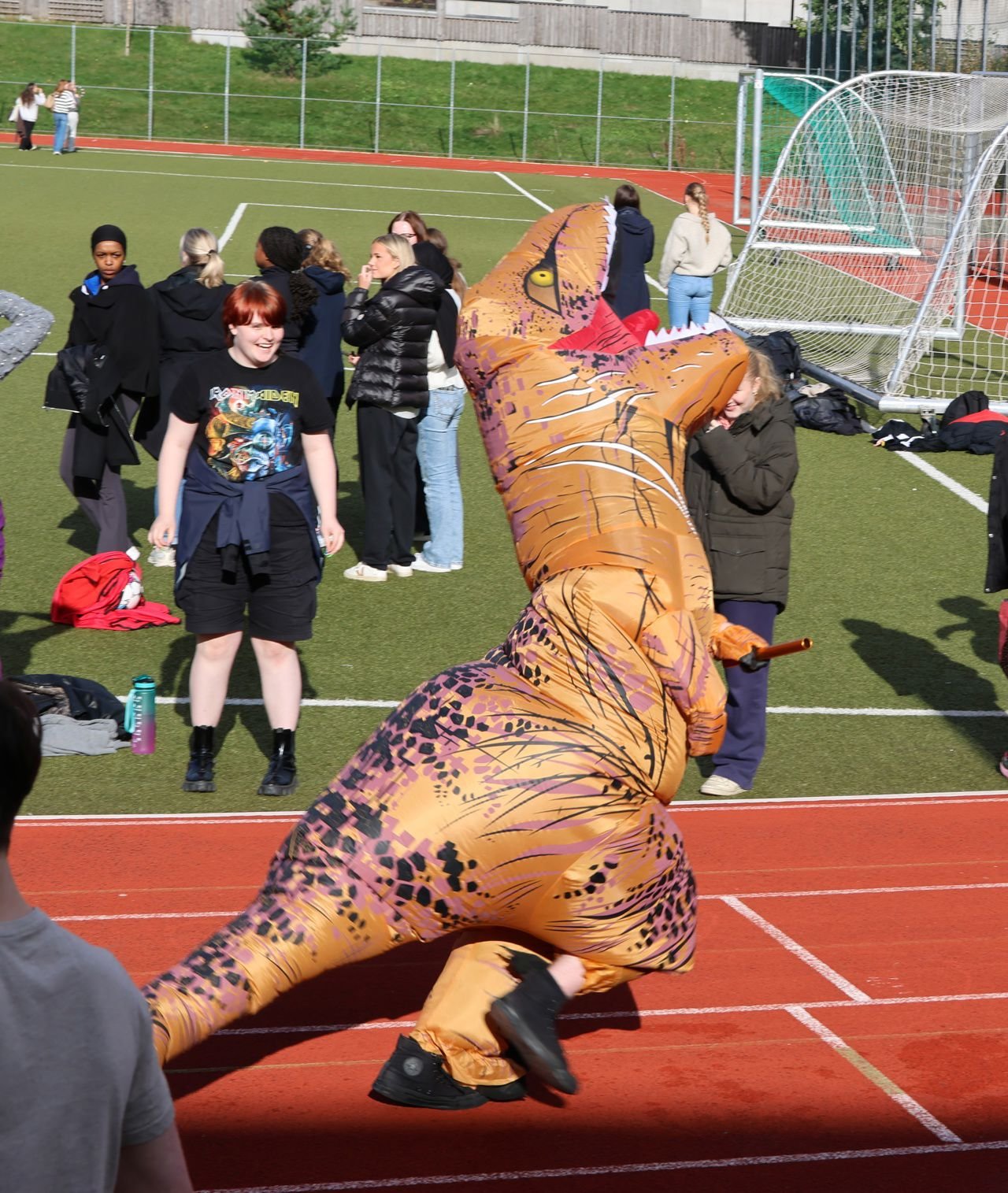 Foto av elev som løper stafett i dinosaurdrakt